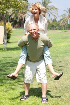 senior citizen giving wife a piggyback ride