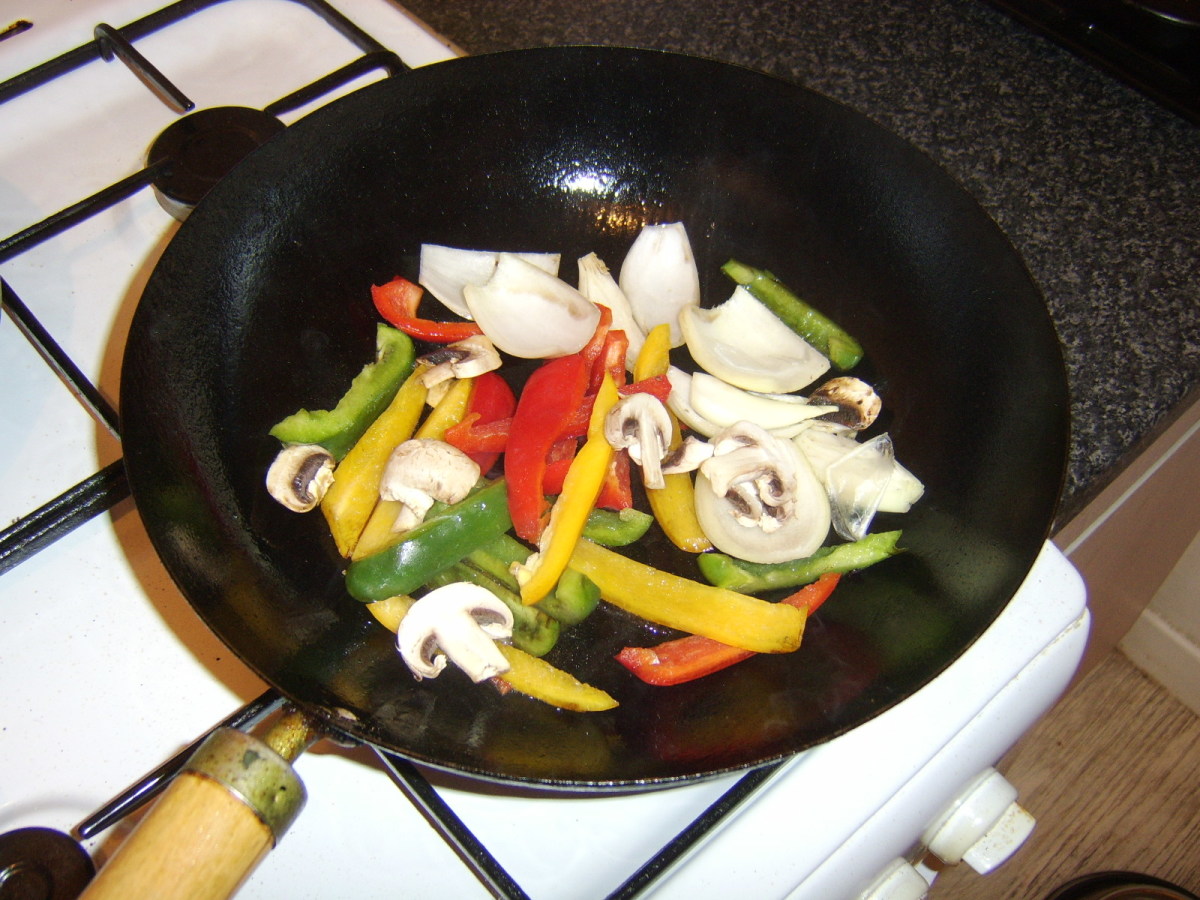 Vegetables are added to a smoking hot wok