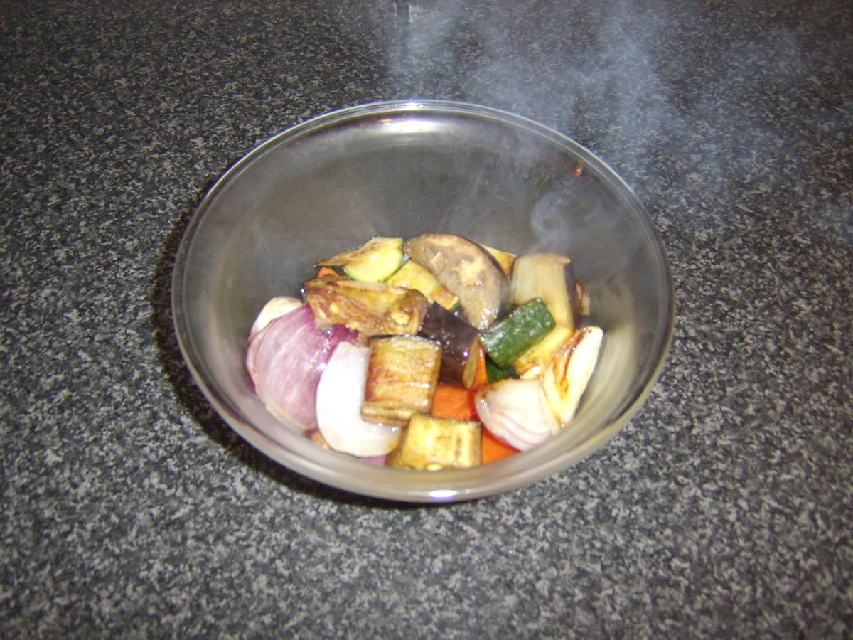 The roasted vegetables and juices are added to a large bowl
