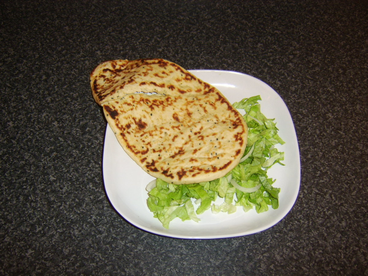 Naan bread and shredded salad are arranged on a plate