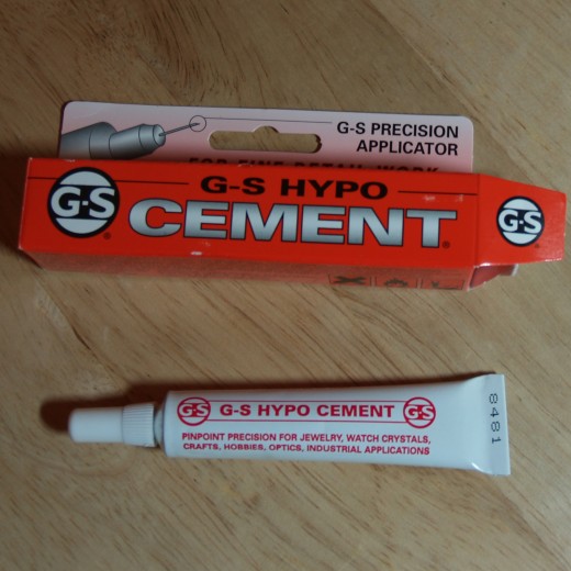 G-S Hypo Cement has a precision applicator which makes it very easy to glue the end of the memory wire into the hole of the half-drilled bead end..