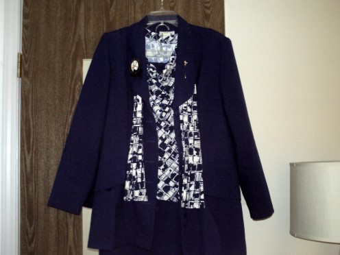 The suit is a skirt suit out of poly poplin.  The blouse and scarf is a set of which I have about 3 that match this suit.  The goal is to have 5 for every suit.  All items are washable.