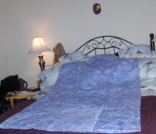 The pocket is pieced top in and on the wrong side of the quillow.  When you snuggle you can put your feet in the pocket.