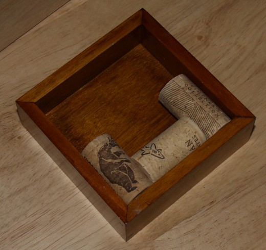 Mahagony coaster with three corks glued into it. Craft kits for many projects using wine corks can be purchased from online suppliers. The corks must be purchased separately.