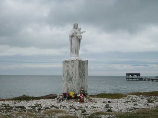 Statue on the beach. Flowers appear daily