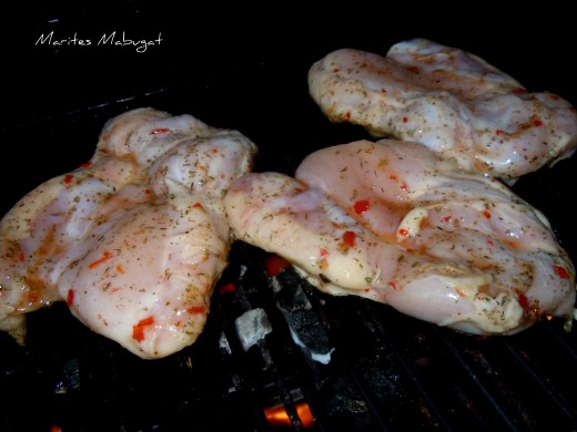 Marinated chicken breasts on screaming hot grill.