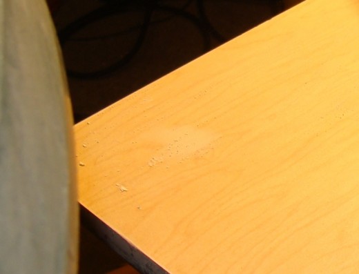 The filled hole should be flush with the table.  Once it is painted there should not be any indication that there had been a hole.
