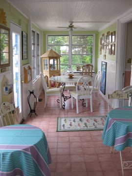 The enclosed front porch is bright and functions as a breakfast room and game room. 