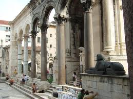 The fantastic classical columns and stonework of the Ancient Peristil with sphynx in the foreground.