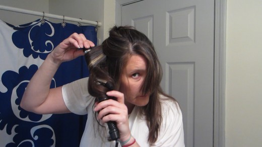 Wrap the hair around the curling iron barrel and pull it through...