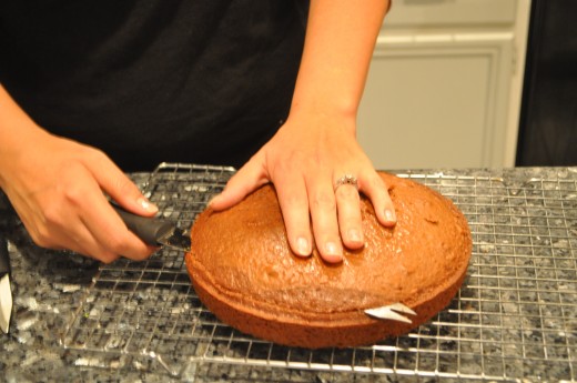Use a very sharp knife to cut the very top off of the cake. This step is optional but having a level cake will make your cake look more professional and easier to decorate. It is also a good excuse to sample the cake before serving!