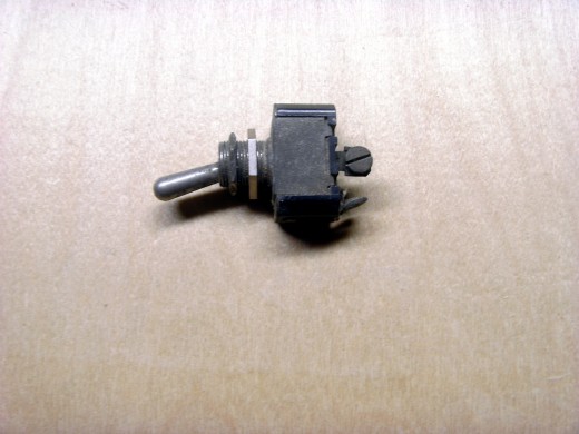 A small toggle switch, commonly found in automotive uses.  The two nuts are used to mount it through sheet metal.