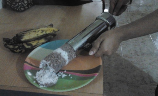 once cooked,  use a stick to push the puttu, out from the puttu maker to a plate