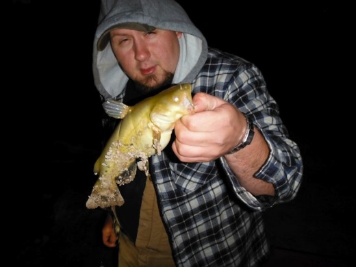 Me and the one catfish I caught. Also note the miserable look on my face from the cold temperature.