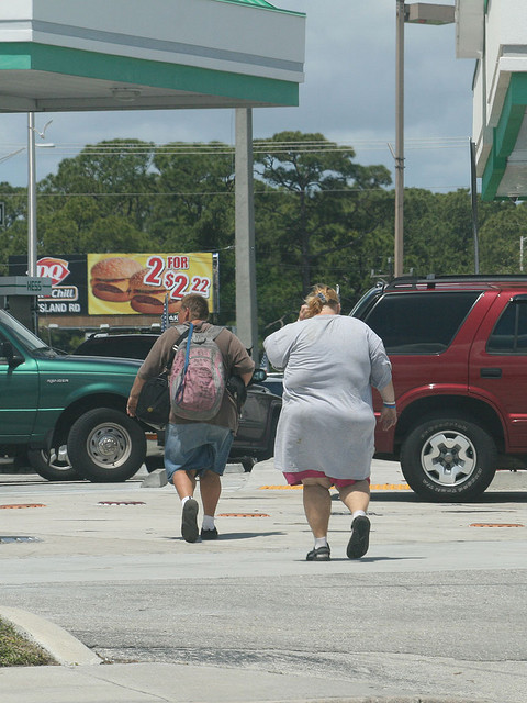 Coincidence or planned? Two overweight people "walking" toward a restaurant that features low-priced specials.