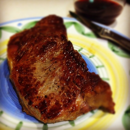 I took this photo of my new york steak for my Hub, "How to Make the Perfect Steak," with Instagram, applied a radial blur to focus on the texture of the steak, and the Valencia filter to correct the lighting from my kitchen at night.
