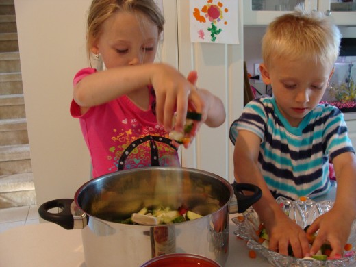 Grace and Alex are having fun putting the vegetables in the pot.