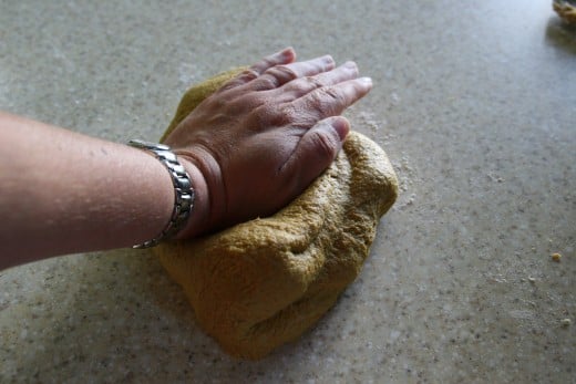 Fold the dough over, rotate by 90 degrees, and press the dough out again.