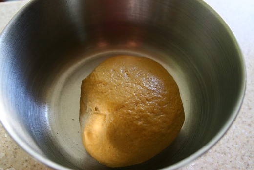 Place the kneaded dough ball in a lightly oiled bowl. Turn the dough so that the dough ball is covered in the oil (this prevents the covering towel from sticking to the dough ball). 