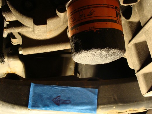 Oil filter is a colorful canister.  The arrow is pointing to the front of the car.
