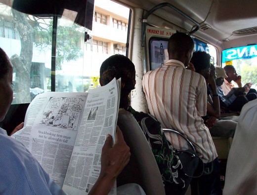 A man reading the Daily Nation of Kenya inside a Dar-es-Salaam "Dala dala" public vehicle