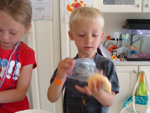 Alex shakes a piece of buttered dough in the shredded cheese.