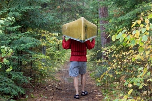 A man carrying a canoe in the Northwoods of the Minnesota  in the Minnesota Boundary Waters Canoe Area Wildnerness
