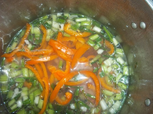 Add desired veggies to cooked rice. At this point the water used to cook rice should be mostly gone. Onion, garlic, orange bell pepper, cavanders, and sea salt.