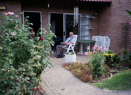 Dad as I want to remember him - enjoying the sunshine on his porch surrounded by flowers