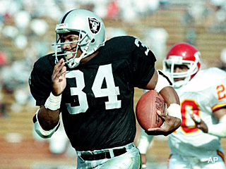 All-World Athlete Bo Jackson rushing the ball for the Oakland Raiders