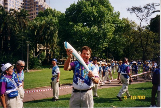 me holding an Olympic Torch as we await the volunteers parade, October 2000, Hyde Park, Sydney.