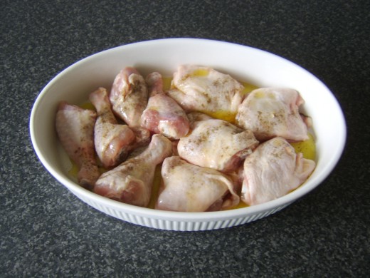 Chicken portions are oiled and seasoned