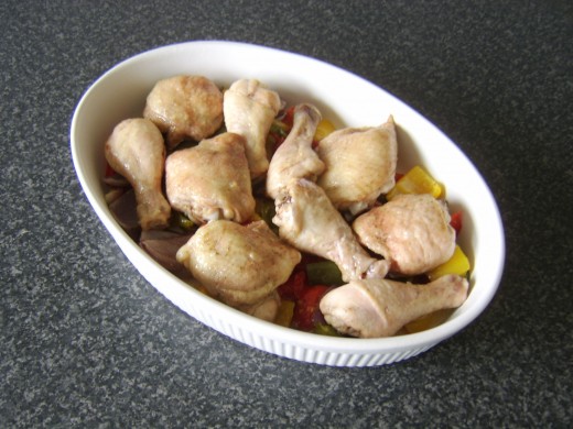 Chicken legs and thighs are returned to the top of the vegetables