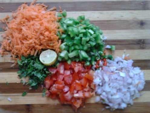 Grate the carrot.  Chop finely onion, green chillies, bell pepper, tomato, coriander leaves. Cut the lime in half. 