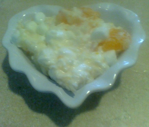 A white heart dish filled with heavenly sweet ambrosia salad. 