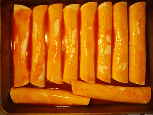 Pour remaining enchilada sauce over tops of tortillas--sprinkle on cheddar cheese.  Then bake.