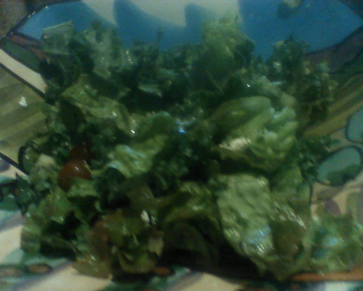 Garden salad of lettuce, kale, kiwi, parsley, and grapes tossed with fresh lemon juice