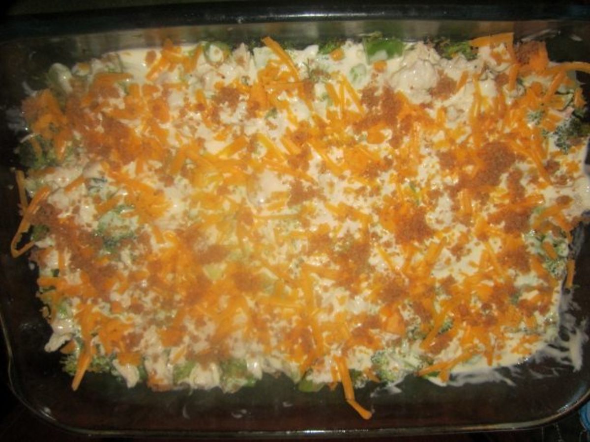 Backed light chicken broccoli divan topped with shredded cheese--all ready to go into the oven. Yummy!