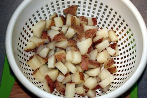 Drain cubed potatoes after boiling.