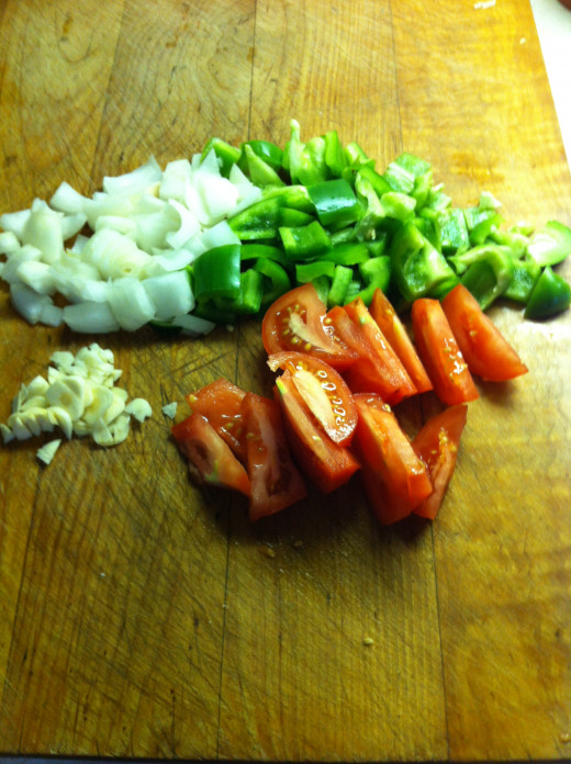 Chop onion, green pepper, and garlic. Slice tomato into sections.