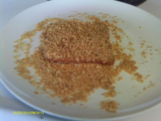 Dip orange juice covered bread in crushed cereal