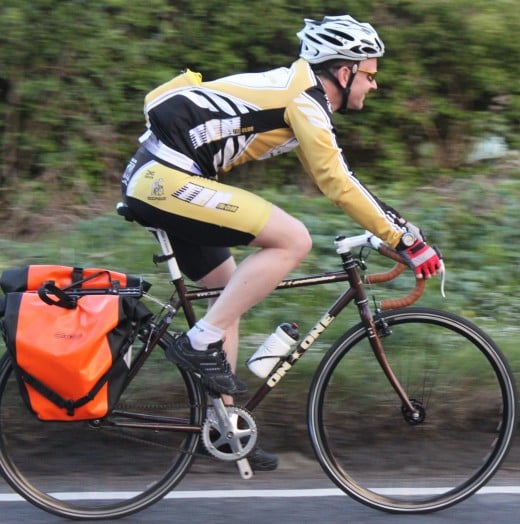 A commuter cyclist riding an On One Pompino bike with panniers on their way home from work