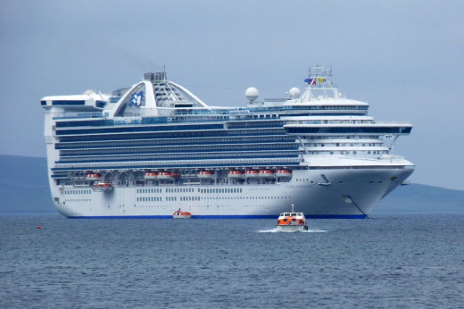 Tenders/life boats are bringing passengers back to the Caribbean Princess cruise ship in Kirkwall harbour in the Orkney Islands, Scotland UK in 2012. Note that the tenders are covered. Also most of the rooms on the ship have balconies.