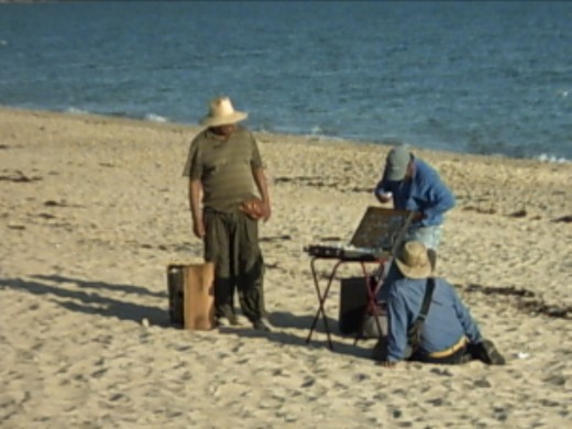 A jewelery vendor sets up shop on the beach.