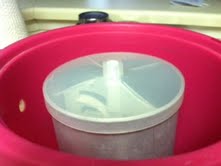 This is how the ice cream container (silver part) fits into the freezer (pink part).  You pack the space between the silver container and the pink with ice (4 parts) and rock salt (1 part), before adding the churn (white part in above picture) on top