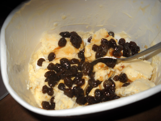 Drunken raisins falling over softened vanilla ice cream.