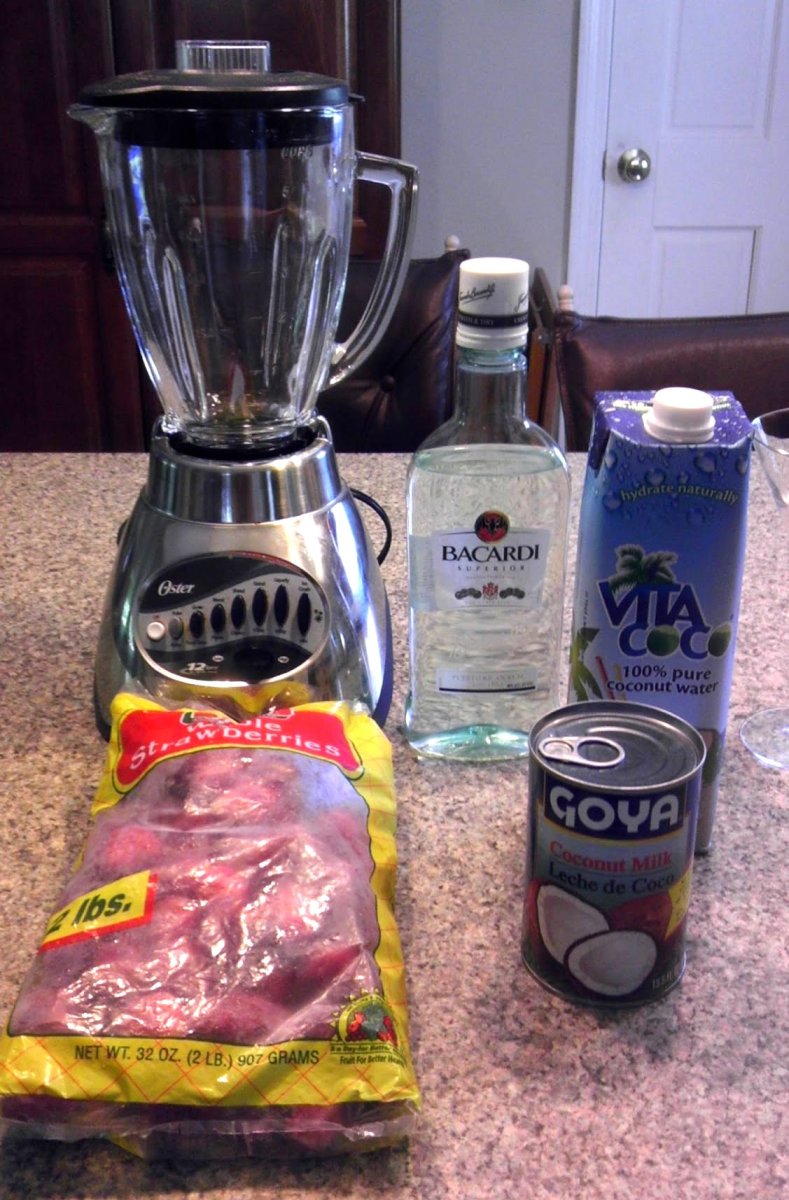Ingredients for a rum smoothie: light rum, frozen strawberries, coconut milk, and coconut water.