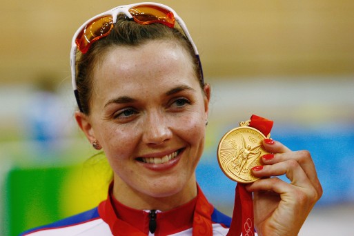 The champion cyclist shows off her gold medal from the women's sprint at Beijing