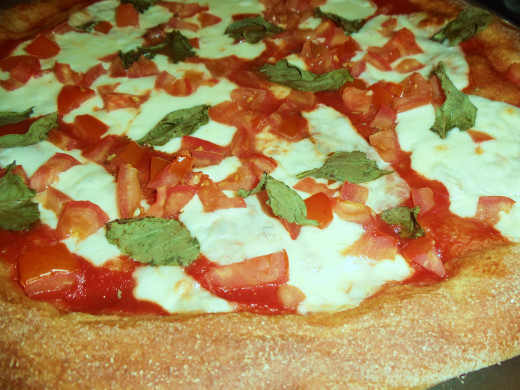 This homemade honey wheat pizza crust recipe is complete with tomatoes and basil from the garden