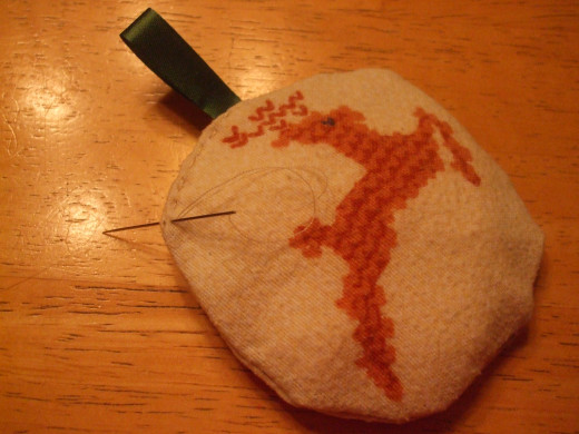 Hand sewing the opening after stuffing the ornament.  This one used 4 cotton balls.